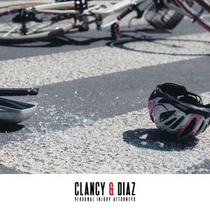 After a bike accident in Benicia, CA, the bicycle and bike helmet on the ground surrounded by broken glass